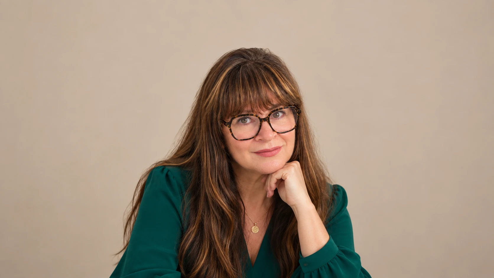 Dr. Alison Feit in a green blouse against a warm beige backdrop